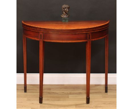 A George III mahogany demilune card table, folding top enclosing an inset baize lined playing surface, tapered square legs, s