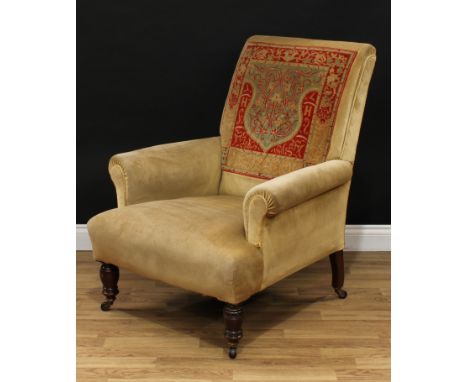 A late Victorian 'carpet' armchair, scroll arms, stuffed-over upholstery, ring-turned forelegs, ceramic casters, 98cm high, 8