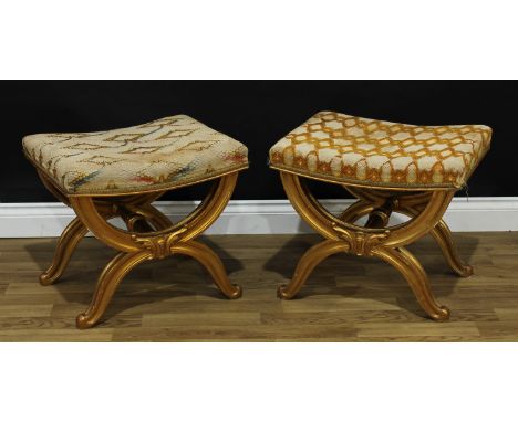 A pair of Italian Baroque design giltwood X-frame stools, each with stuffed-over rectangular seat, turned and octagonal panel