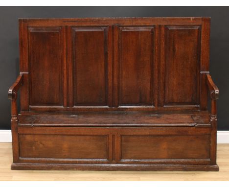 An 18th century oak box settle, rectangular back with four raised and fielded panel, downswept arms, cylindrical arm posts, h
