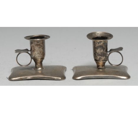 A pair of 19th century Russian silver chamber sticks, bell shaped sconces, the incurved rounded rectangular bases engine turn