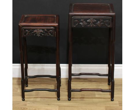 A graduated pair of Chinese hardwood occasional tables, panel tops, shaped friezes pierced and carved with fruiting vine, sha