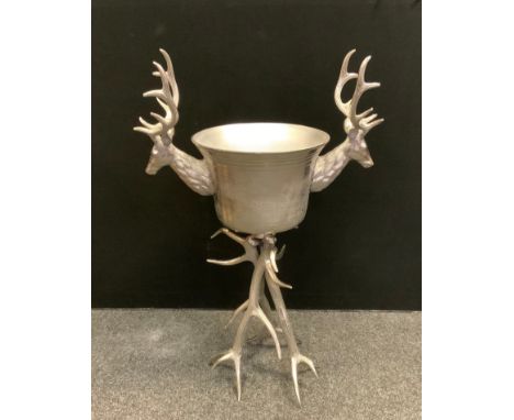 A large polished metal free standing Ice bucket with stylised stag antler handles and tripod feet, 105cm high, 69cm wide. 
