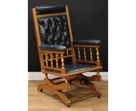 A 19th century giltwood rocking chair, deep-button stuffed-over upholstery, spindle galleries, turned stretcher, 106cm high, 