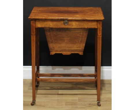 An Edwardian rosewood work table, hinged rectangular top enclosing a compartmented interior, the central cover removable to a
