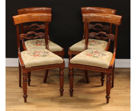 A set of four William IV mahogany dining chairs, each with a curved cresting rail above a shaped and pierced foliate carved m