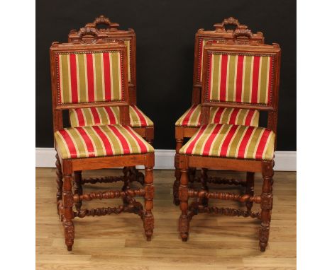 A set of four Cromwellian Revival oak dining chairs, each with a rectangular back with architectural leafy cresting, stuffed-