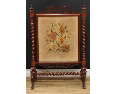 A Victorian walnut and mahogany firescreen, rectangular banner worked in wool with flowers and leaves, fretwork cresting, spi
