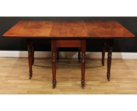 A 19th century mahogany gateleg dining table, rectangular top with fall leaves, ring-turned legs, ceramic casters, 73.5cm hig