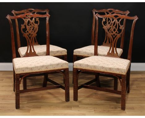 A set of four Chippendale Revival mahogany dining chairs, of broad proportions, each with a cupid's bow cresting rail above a