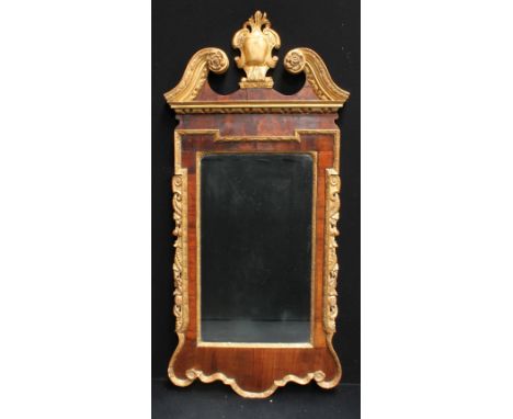 A 19th century giltwood and mahogany looking glass, in the manner of William Kent, architectural swan neck pediment centred b
