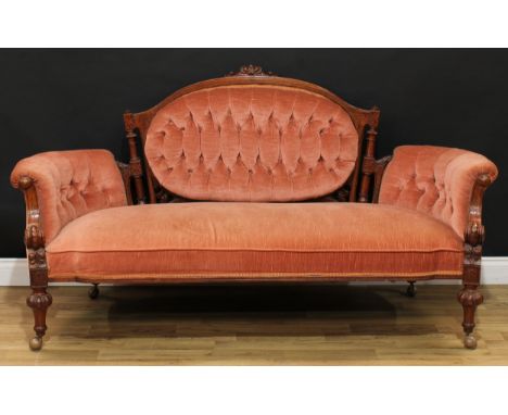 A Victorian walnut sofa, shaped arched back with leafy cresting and flanked by turned pillars, incise carved throughout, deep