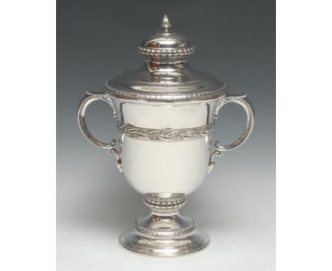 A large George V silver two-handled trophy cup and cover, leafy knop finial, fruiting laurel girdle, domed foot, 35cm high, J