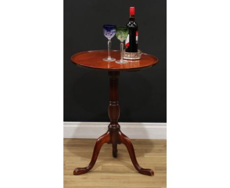 A 19th century mahogany tripod occasional table, dished circular tilting top, canon-barrel column, cabriole legs, pointed pad