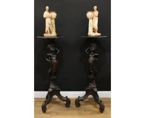 A pair of Venetian softwood blackamoor torcheres, each carved and painted as a scantily clad attendant, shaped oval plateaux,