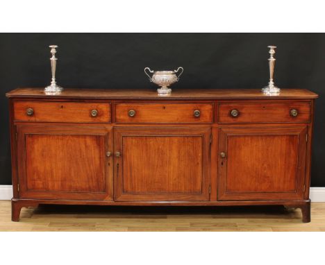 A George III mahogany low dresser or serving cabinet, slightly oversailing rectangular top with reeded edge above three short