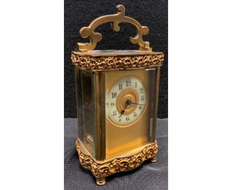 A late 19th century gilt metal serpentine fronted carriage clock, Arabic chapter ring, applied cast foliate scroll border, 11