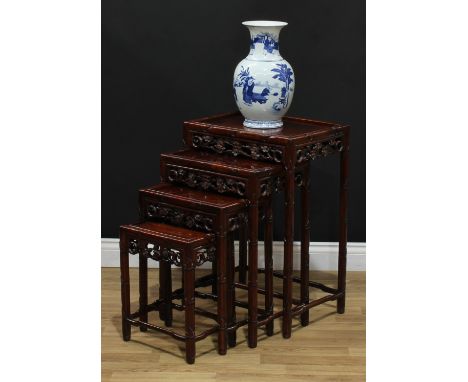 A quartet of Chinese hardwood occasional tables, each with a rectangular panel top, shaped and pierced frieze carved with blo