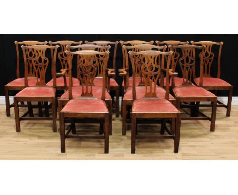 A set of twelve Provincial Chippendale Revival oak dining chairs, comprising a pair of carvers and ten side chairs, Cupid's b