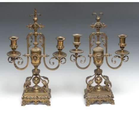 A pair of French gilt brass two-light candelabra, half-fluted campana sconces, pierced and cast throughout with fleur-de-lys 