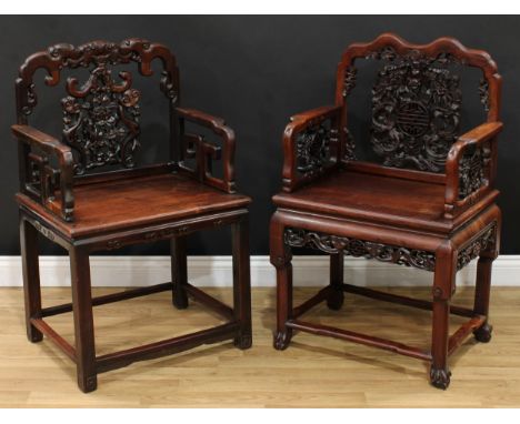 A Chinese hardwood armchair, shaped cresting rail, the back pierced and profusely carved with double happiness and dragons am