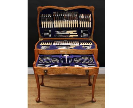 An Art Deco period burr walnut serpentine canteen table, enclosing a George VI service of silver flatware, for twelve, compri