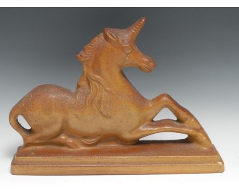 A 19th century salt glazed stoneware model or door stop, as a recumbent unicorn, stepped rectangular base, 38cm wide, c.1840 