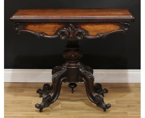 A Victorian rosewood card table, hinged top with moulded edge enclosing a baize lined playing surface, above a frieze carved 