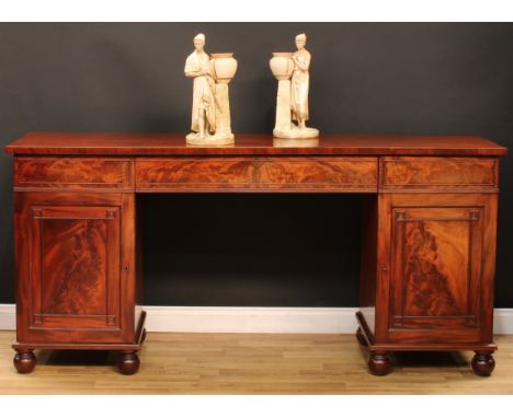 A 'Post-Regency George/William IV' mahogany and flame mahogany sideboard, slightly oversailing rectangular top above a centra