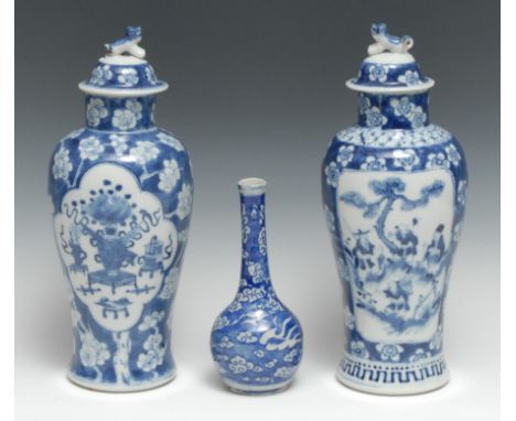 A Chinese waisted baluster vase and covers, decorated with precious objects within shaped reserves, the ground with blossomin