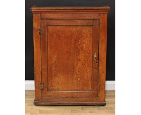 A George III oak provision cupboard, moulded cornice above a rectangular panel door enclosing shelves and spice drawers, 105c