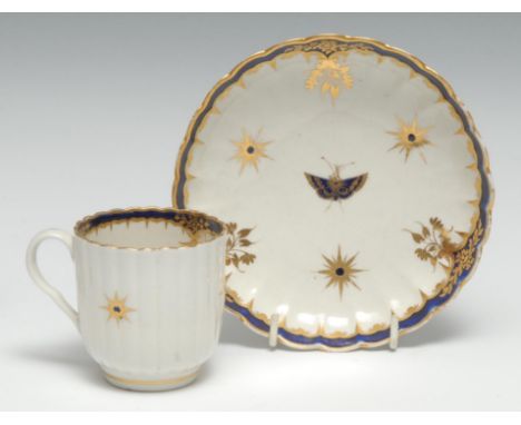 A Worcester fluted coffee cup and saucer,  painted in blue and gilt with stars and leaves, the saucer with a butterfly, cresc