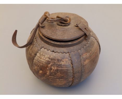 An antique iron-mounted spherical wooden caddy, the hinged iron cover  with integral lock, fitted with a central link and hoo