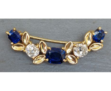 A sapphire &amp; old cut diamond yellow metal brooch, of curved form comprising three cushion cut sapphires in four-claw sett