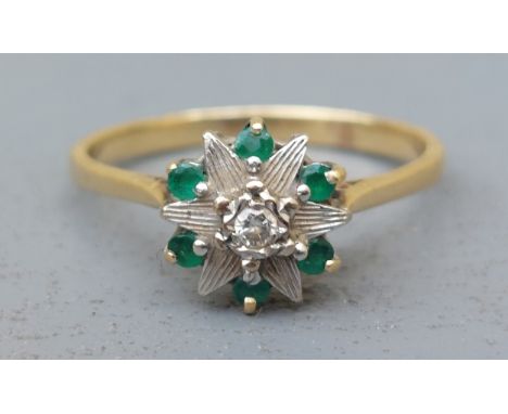 A modern emerald &amp; diamond set cluster ring on '18ct' shank.  Finger size R/S.