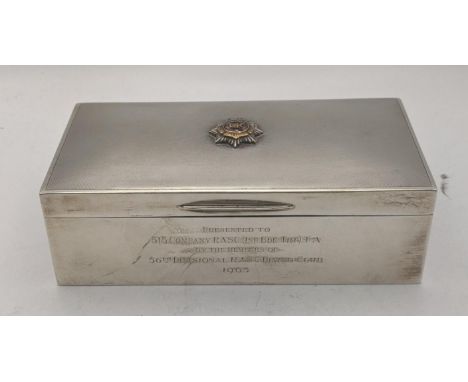 A silver cigarette box with an engine turned lid and also having a Royal army service corks to the top and engraved to the fr
