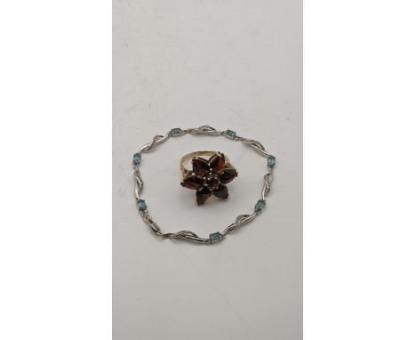 A yellow garnet flower ring tested as 9ct gold 6.2g together with a silver and blue topaz braceletLocation:If there is no con