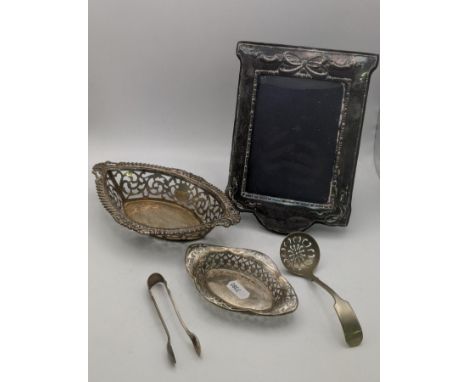 Silver to include two pierced dishes, a pair of sugar tongs and a silver framed photo frame and a silver plated ladle total w