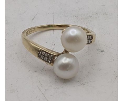 A 9ct gold ring set with two cultured pearls and white topaz, size S, 3.1g, with a certificate of authenticityLocation:If the