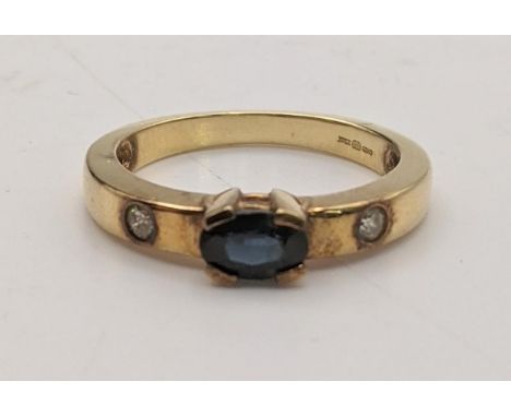 An 18ct gold ring faceted with an oval blue sapphire, flanked by diamonds, size M 1/2, 4.1gLocation:If there is no condition 