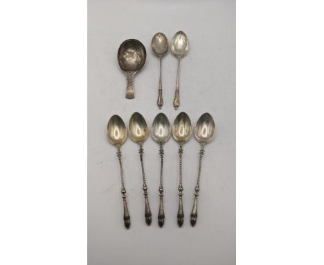 A set of white metal teaspoons having twisted hoof turbinals together with a silver tea caddy spoon having a floral etched bo