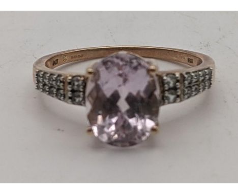 A 9ct rose gold ring set with an oval Mawi kunzite flanked by white zircons size Q, 2.9g with a certificate of authenticityLo