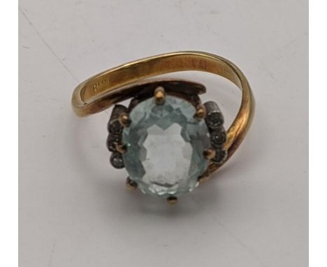 An 18ct gold ring having a central oval cut aquamarine in claw setting flanked by diamonds, size O 1//2Location:If there is n