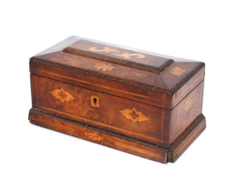 An early 19th Century inlaid walnut tea caddy, of sarcophagus form having fluted borders, decorated stylised flowers and colo