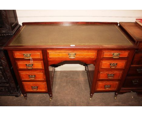 A 19th Century mahogany and cross banded kneehole desk, fitted single long drawer above a cupboard flanked by six short drawe