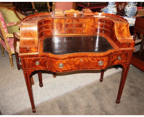 An early 20th Century mahogany Carlton House writing desk in the Sheraton manner, having a raised upper section fitted drawer