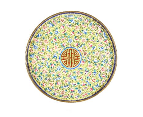 An 18th Century painted enamel yellow ground circular tray, painted with various flowers and fruits with a central shou chara
