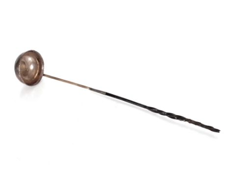 A Georgian unmarked white metal punch ladle, having coin decoration to the bowl and twist horn handle 