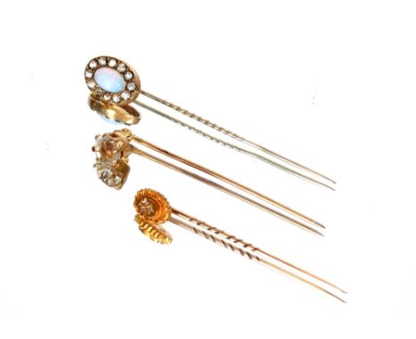 A 15ct gold and diamond stick pin; a yellow metal and white stone set stick pin; and a yellow metal opal and white stone set 