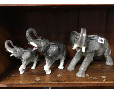 A group of three graduated ceramic elephants